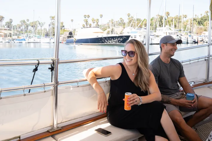 a man and a woman sitting on a bench posing for the camera