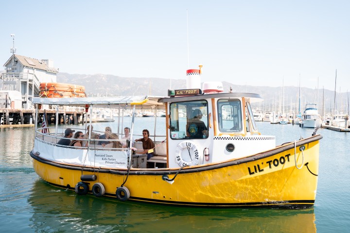 Yellow boat named Lil Toot with passengers, dock in background.